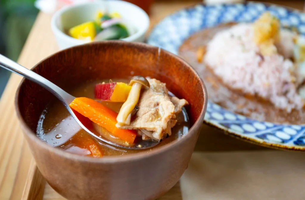 大きなチキンと野菜が入った札幌スープカレー
